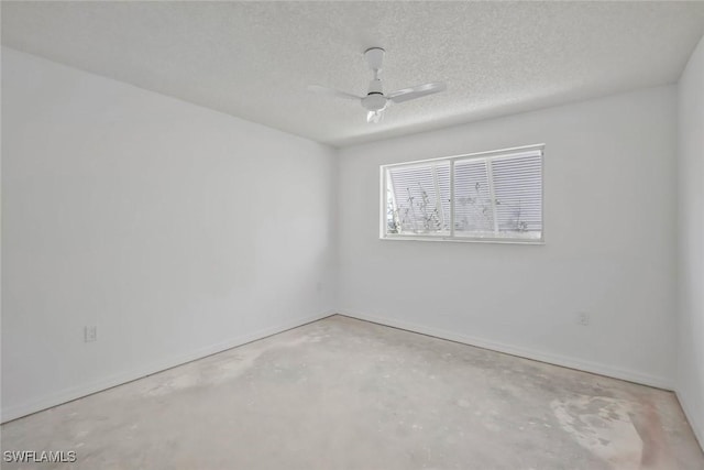 spare room with unfinished concrete floors, baseboards, ceiling fan, and a textured ceiling