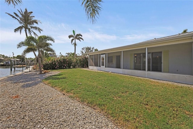 view of yard featuring a water view and a sunroom