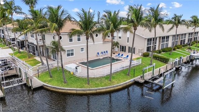 4938 Viceroy St Unit 107, Cape Coral, FL 33904 - rear view of house featuring fence, boat lift, stucco siding, a lawn, and a water view