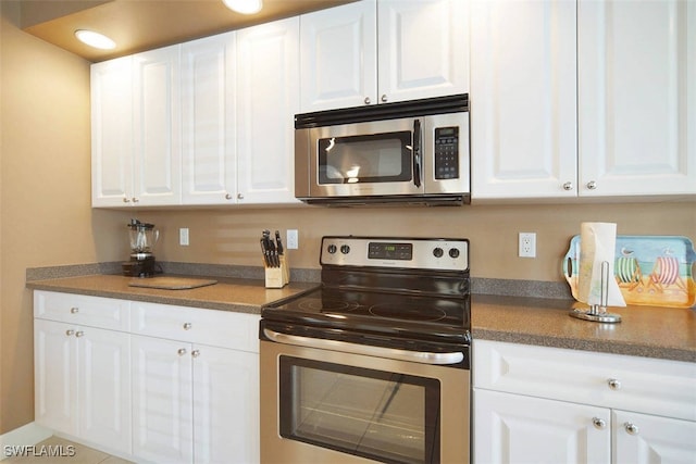 1725 SE 10th Pl, Cape Coral, FL 33990 - kitchen with white cabinetry, dark countertops, and stainless steel appliances