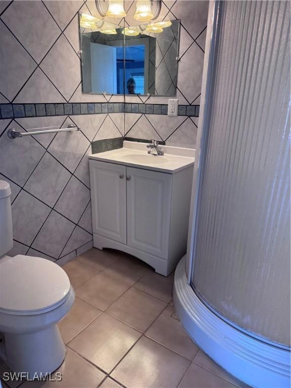 2739 Michigan Ave, Fort Myers, FL 33916 - bathroom featuring tile walls, tile patterned floors, a chandelier, vanity, and toilet
