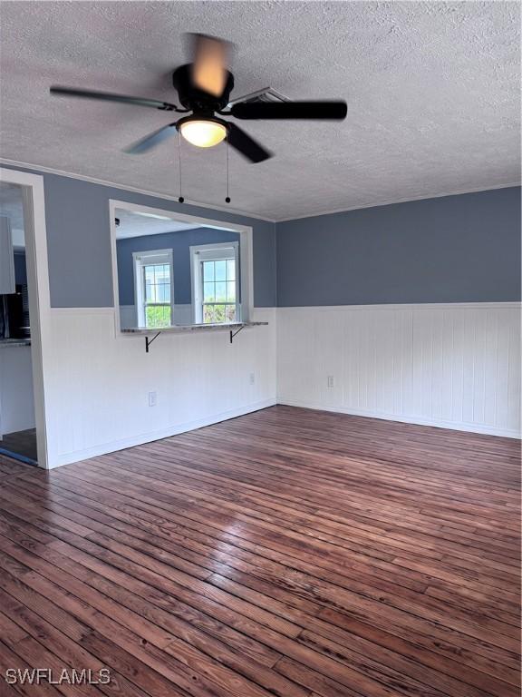 2739 Michigan Ave, Fort Myers, FL 33916 - spare room with a textured ceiling, dark wood-style floors, a ceiling fan, and wainscoting