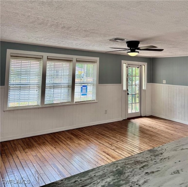2739 Michigan Ave, Fort Myers, FL 33916 - spare room featuring hardwood / wood-style floors, a textured ceiling, a wainscoted wall, and a ceiling fan