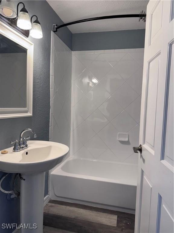 2739 Michigan Ave, Fort Myers, FL 33916 - full bath with wood finished floors, bathtub / shower combination, a textured wall, and a textured ceiling