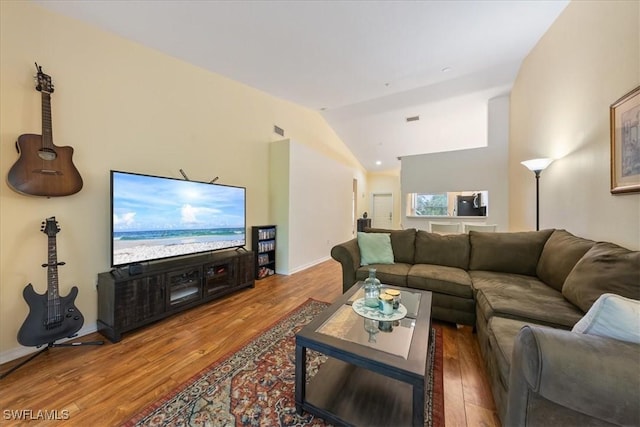 6645 Huntington Lakes Cir Unit 202, Naples, FL 34119 - living area with visible vents, baseboards, wood finished floors, and vaulted ceiling