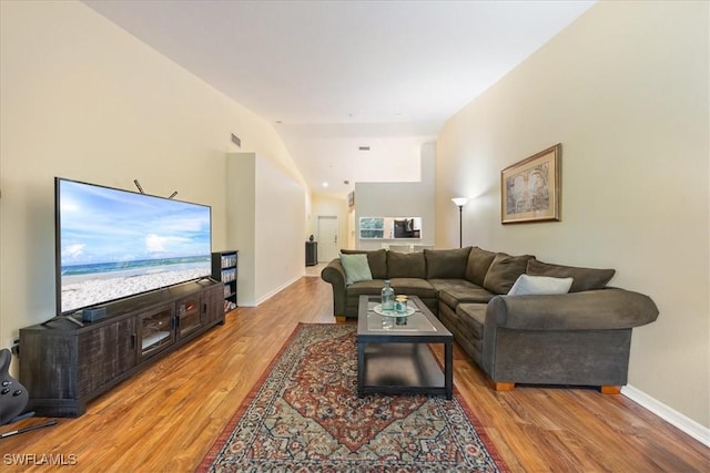 6645 Huntington Lakes Cir Unit 202, Naples, FL 34119 - living room with baseboards, wood finished floors, vaulted ceiling, and visible vents