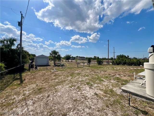 view of yard featuring a detached garage and fence