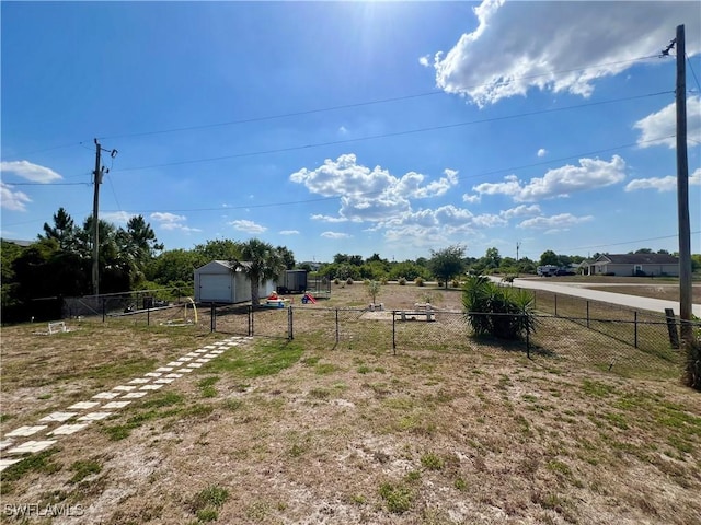 view of yard with a garage, dirt driveway, and fence