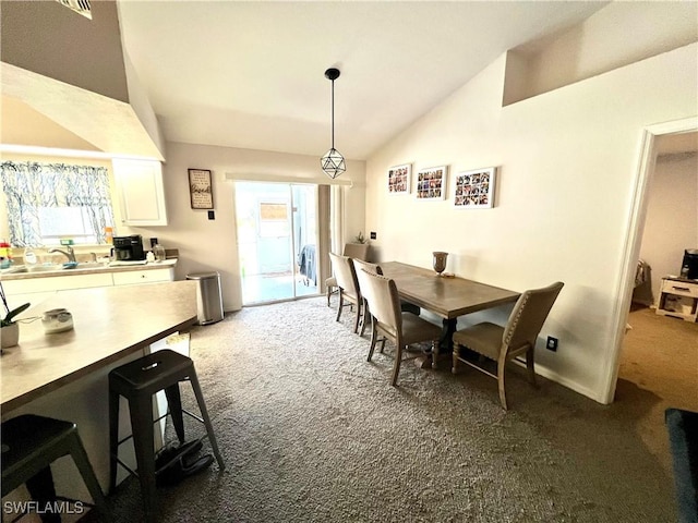 dining room with baseboards, a healthy amount of sunlight, lofted ceiling, and dark colored carpet