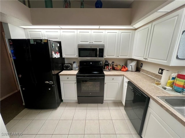 kitchen featuring light tile patterned floors, light countertops, a sink, black appliances, and white cabinetry