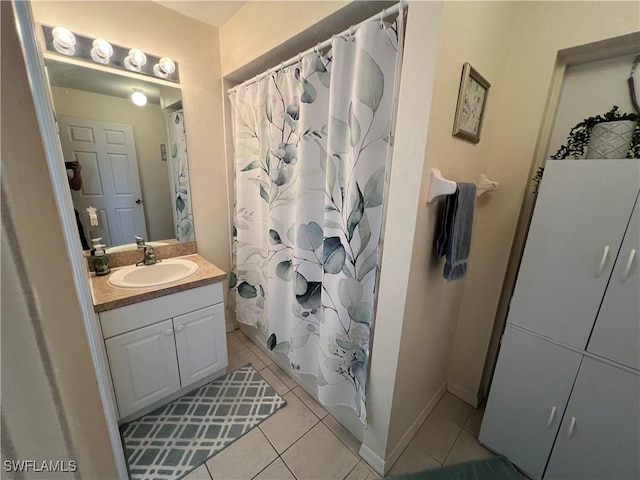 bathroom with vanity, baseboards, tile patterned floors, and curtained shower