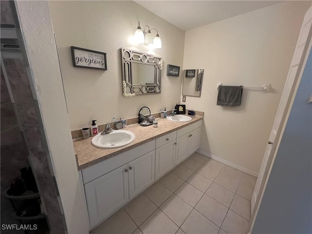full bathroom featuring a sink, tile patterned floors, baseboards, and double vanity