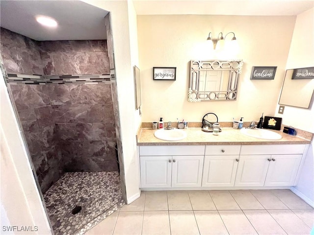 full bath with a sink, tile patterned floors, and tiled shower