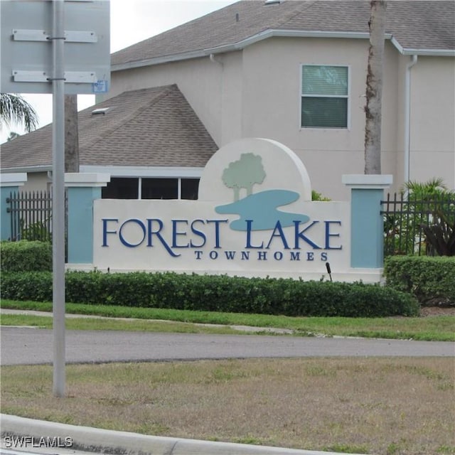 community / neighborhood sign featuring fence