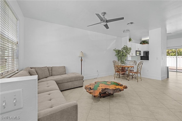 living area with baseboards, a ceiling fan, light tile patterned flooring, and visible vents