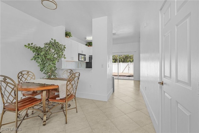 dining room featuring baseboards and light tile patterned floors