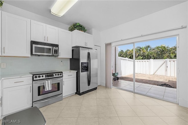 3646 Pine Oak Cir Unit 102, Fort Myers, FL 33916 - kitchen with light tile patterned floors, backsplash, white cabinets, and stainless steel appliances