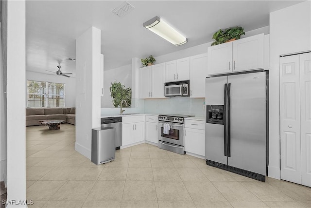 kitchen with ceiling fan, a sink, light countertops, stainless steel appliances, and white cabinetry