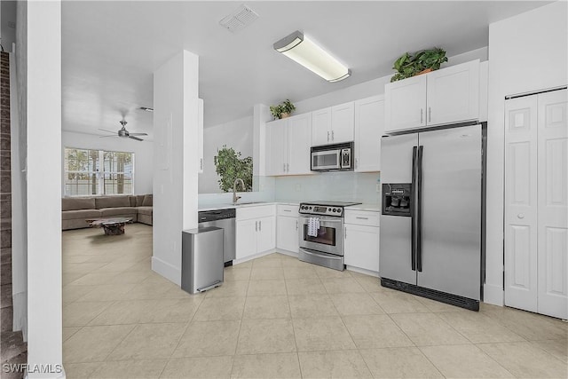kitchen with ceiling fan, a sink, light countertops, stainless steel appliances, and white cabinetry