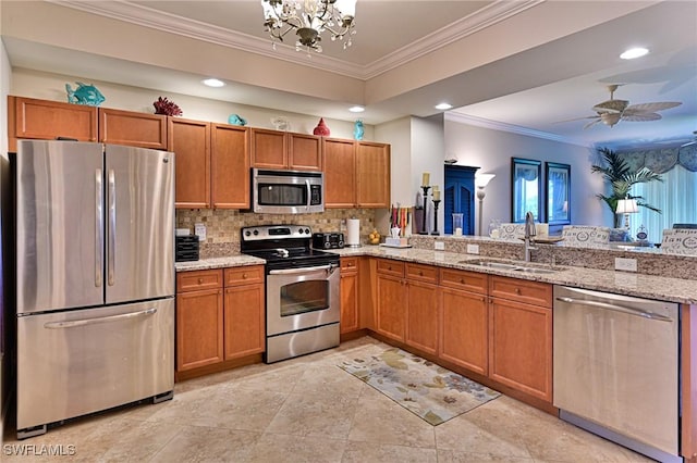 kitchen with brown cabinetry, tasteful backsplash, a sink, ornamental molding, and stainless steel appliances