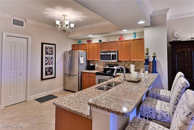 kitchen with a sink, brown cabinetry, stainless steel appliances, and visible vents