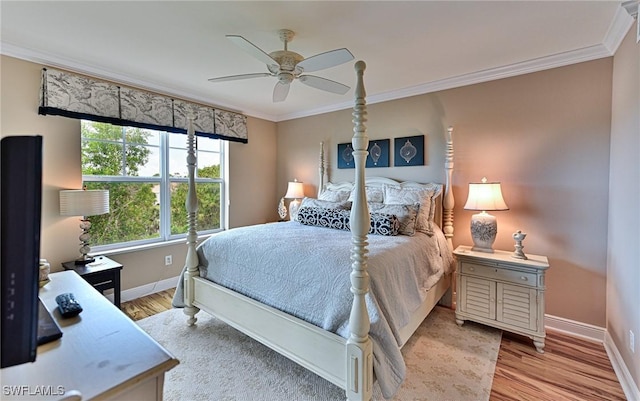 bedroom featuring crown molding, baseboards, light wood finished floors, and ceiling fan