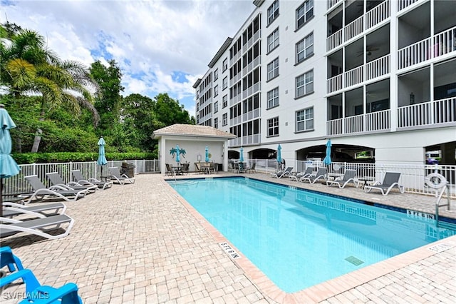 community pool with fence and a patio