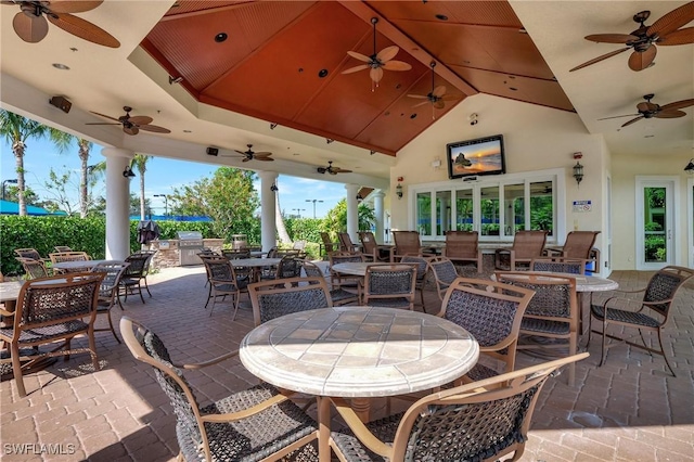 view of patio featuring an outdoor kitchen, outdoor dining space, ceiling fan, and a grill