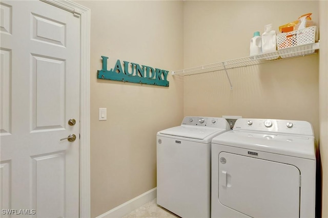 laundry room with baseboards, laundry area, and washer and dryer