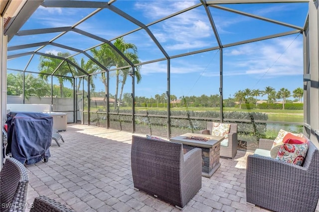 view of patio featuring a lanai, a jacuzzi, a fire pit, and area for grilling