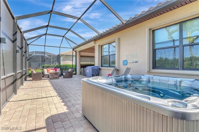 view of patio / terrace featuring a lanai, a hot tub, and outdoor lounge area