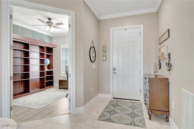 foyer featuring visible vents, ornamental molding, baseboards, and ceiling fan