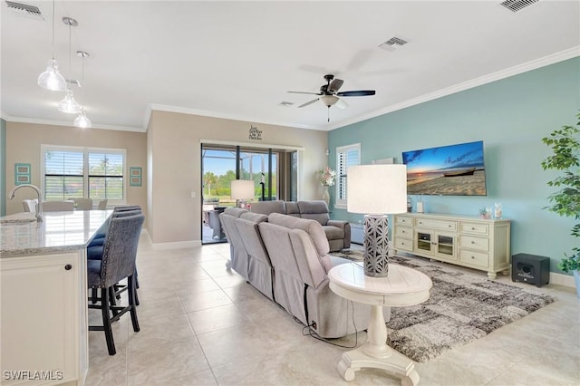 living room with a ceiling fan, baseboards, visible vents, and ornamental molding