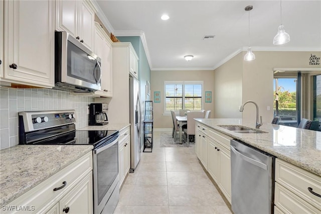 kitchen featuring a sink, stainless steel appliances, tasteful backsplash, visible vents, and ornamental molding