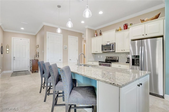 11716 Avingston Ter, Fort Myers, FL 33913 - kitchen featuring appliances with stainless steel finishes, a sink, tasteful backsplash, ornamental molding, and an island with sink