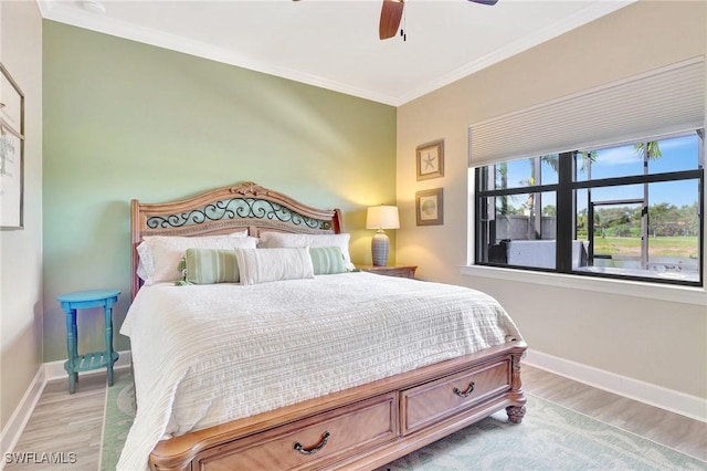 bedroom with baseboards, ornamental molding, a ceiling fan, and wood finished floors