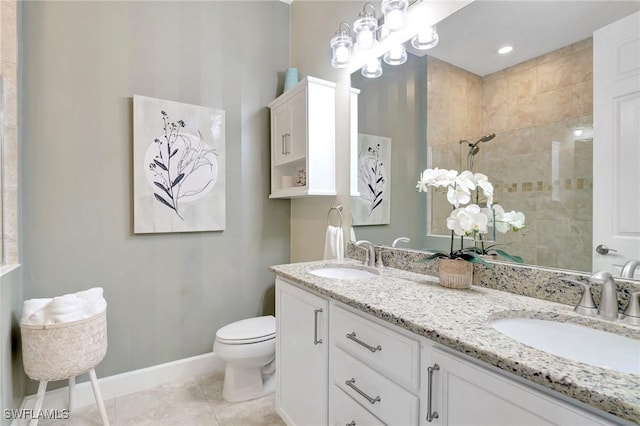 bathroom with baseboards, a sink, tile patterned flooring, and tiled shower