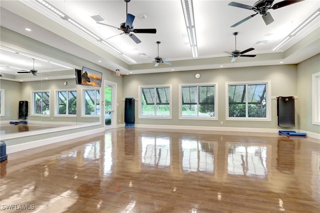 interior space featuring a ceiling fan, crown molding, baseboards, a tray ceiling, and recessed lighting