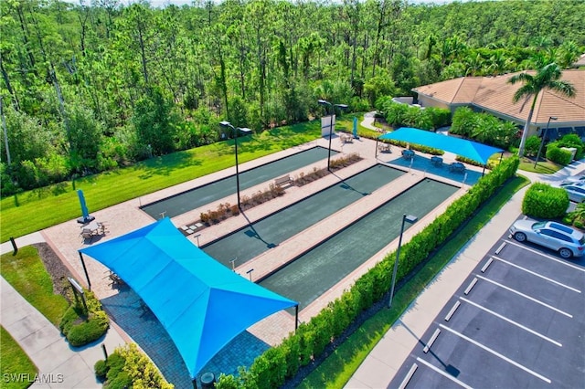 11716 Avingston Ter, Fort Myers, FL 33913 - surrounding community with a bocce ball area, a forest view, and uncovered parking