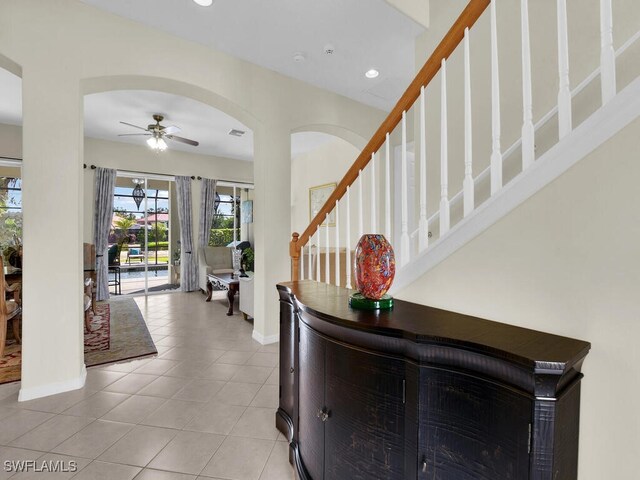 12156 Ledgewood Cir, Fort Myers, FL 33913 - foyer entrance with baseboards, light tile patterned floors, ceiling fan, and arched walkways