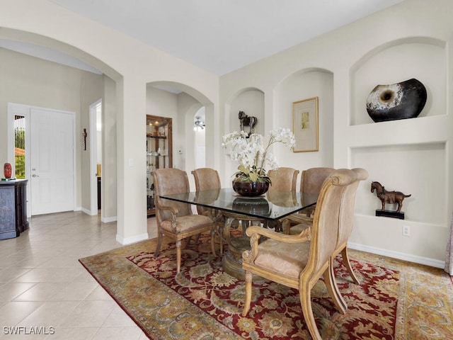 12156 Ledgewood Cir, Fort Myers, FL 33913 - dining area with light tile patterned flooring, arched walkways, and baseboards