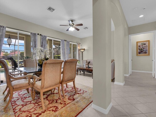 12156 Ledgewood Cir, Fort Myers, FL 33913 - dining area featuring visible vents, ceiling fan, arched walkways, light tile patterned floors, and baseboards