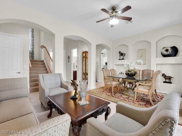 12156 Ledgewood Cir, Fort Myers, FL 33913 - living room with light tile patterned floors, visible vents, ceiling fan, stairs, and arched walkways
