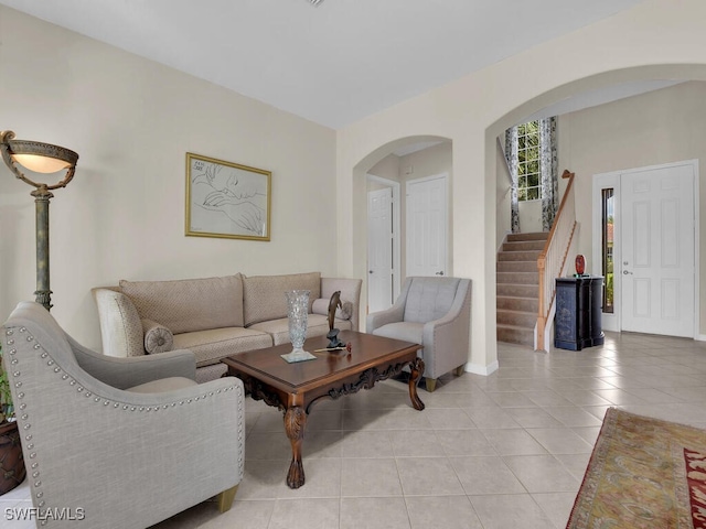 12156 Ledgewood Cir, Fort Myers, FL 33913 - living area featuring stairway, arched walkways, baseboards, and light tile patterned floors