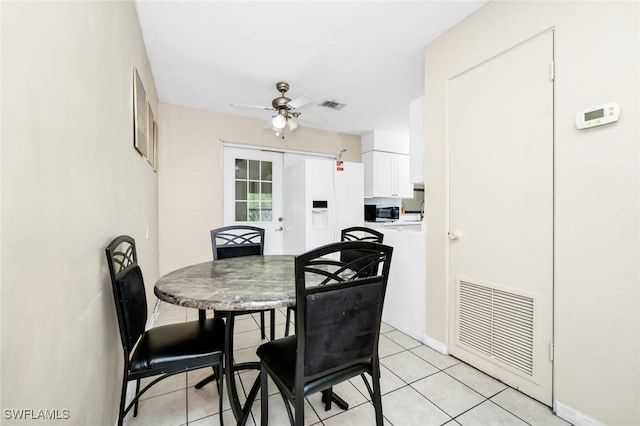 dining room featuring visible vents, baseboards, ceiling fan, and light tile patterned flooring