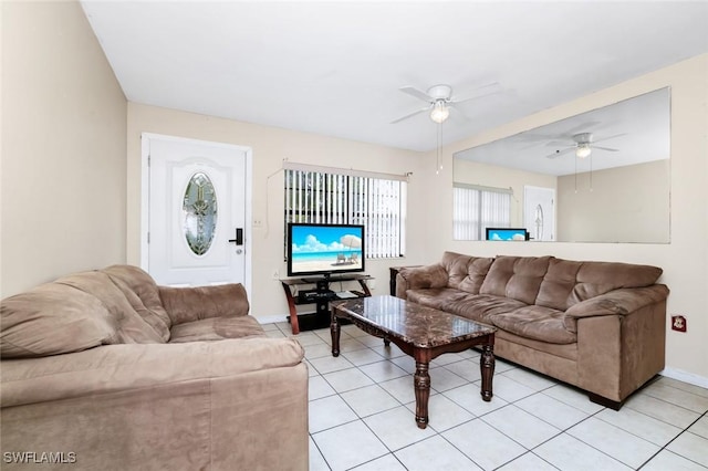 living area with baseboards, ceiling fan, and light tile patterned floors