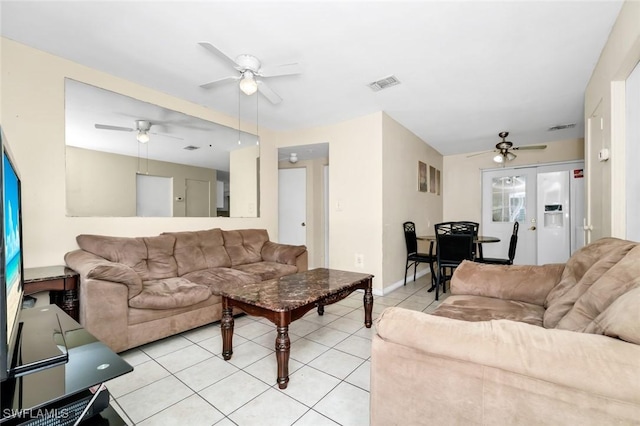 living room featuring light tile patterned floors, baseboards, a ceiling fan, and visible vents