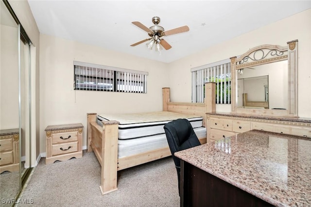 carpeted bedroom featuring a closet and a ceiling fan