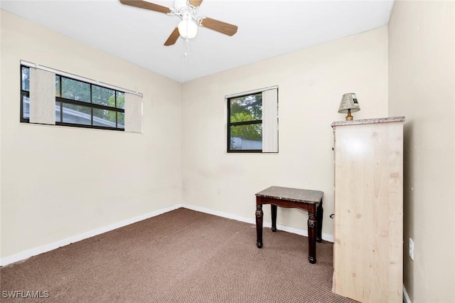 carpeted spare room with baseboards, ceiling fan, and a healthy amount of sunlight