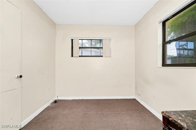 spare room featuring baseboards and carpet